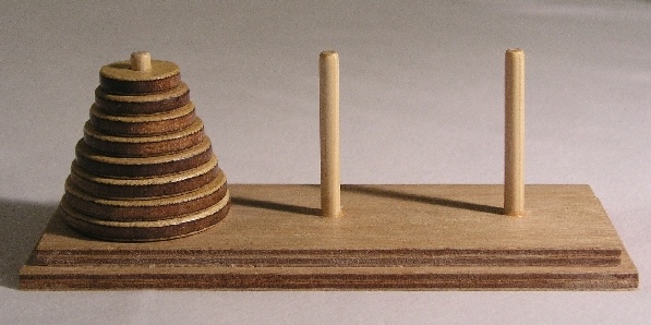Photo of three pegs, with a stack of 8 disks on the left-most peg, stacked biggest-to-smallest